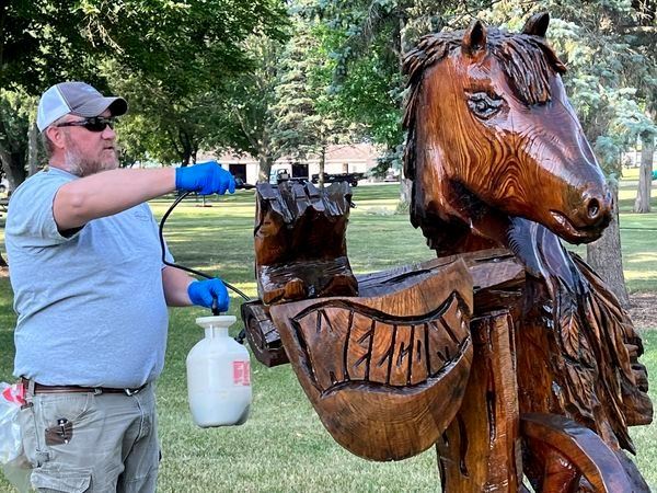 ISG applying sealant to wood carvings