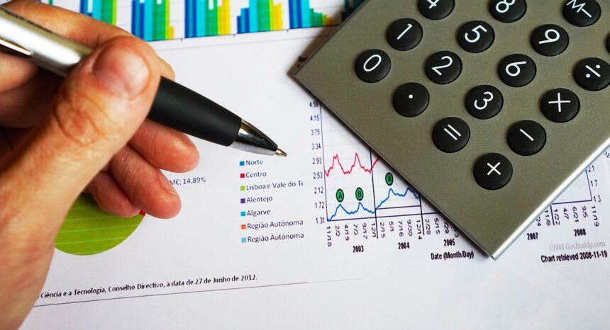 Hand-holding-a-pen-and-a-calculator-860x466